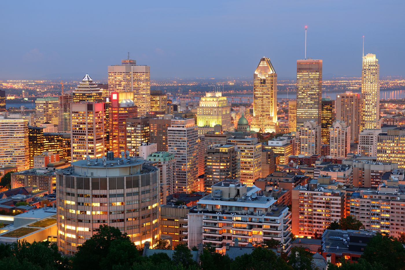 A dense downtown skyline lit up at dusk